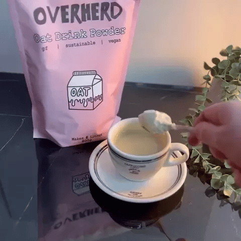 Oat milk powder being stirred into coffee