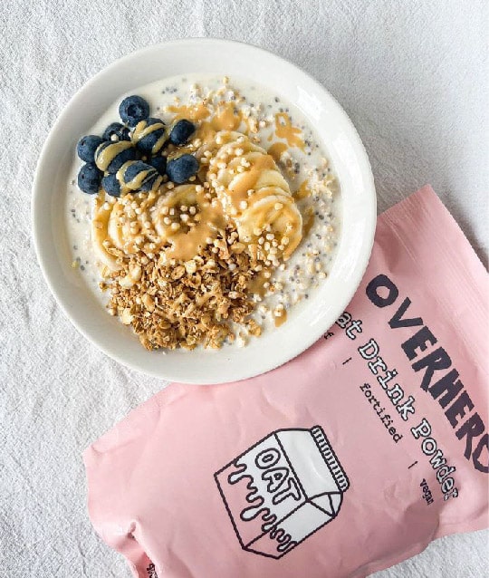 Overherd oat milk powder next to a bowl of porridge