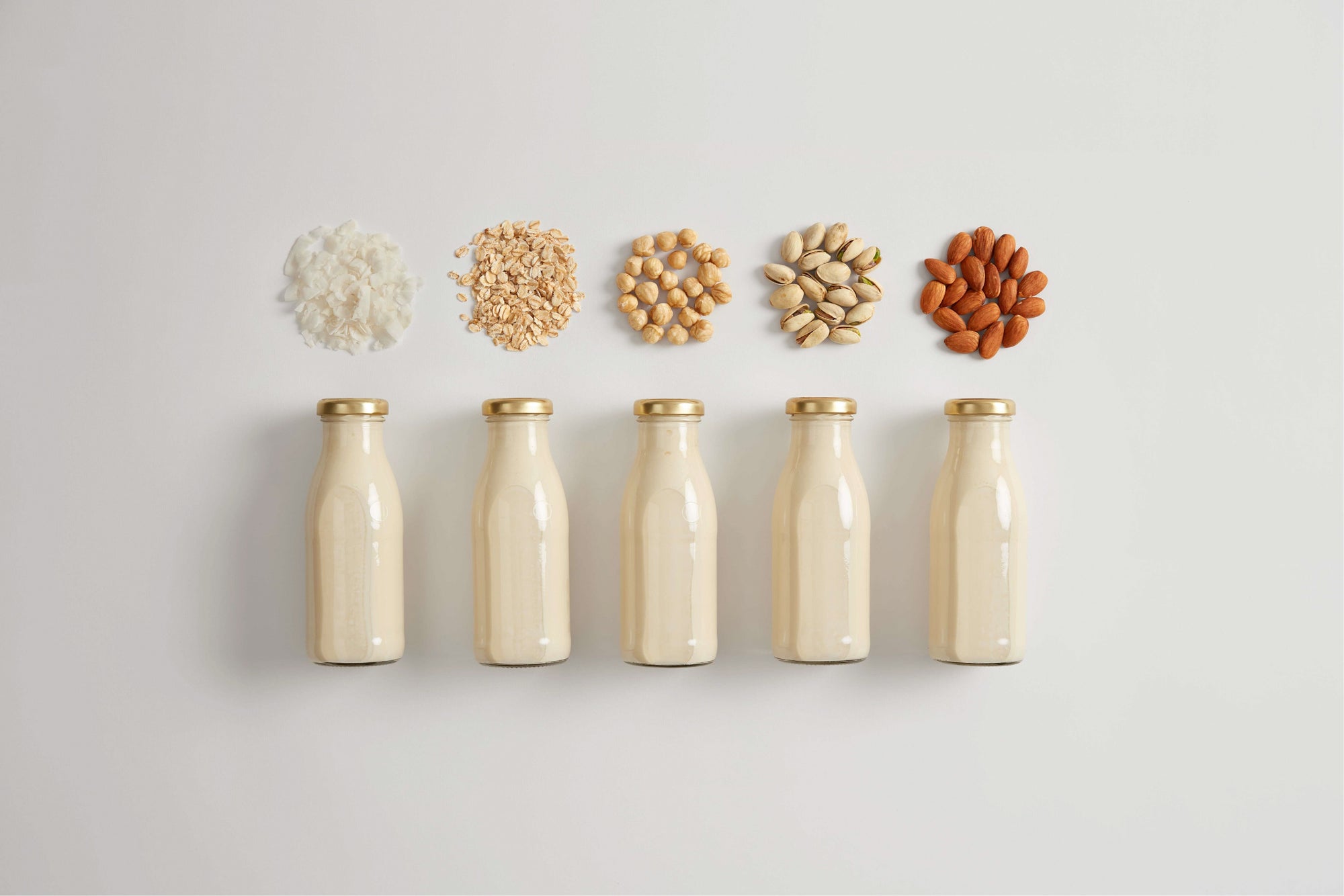 Vegan milk powder substitutes represented by five plant milk bottles