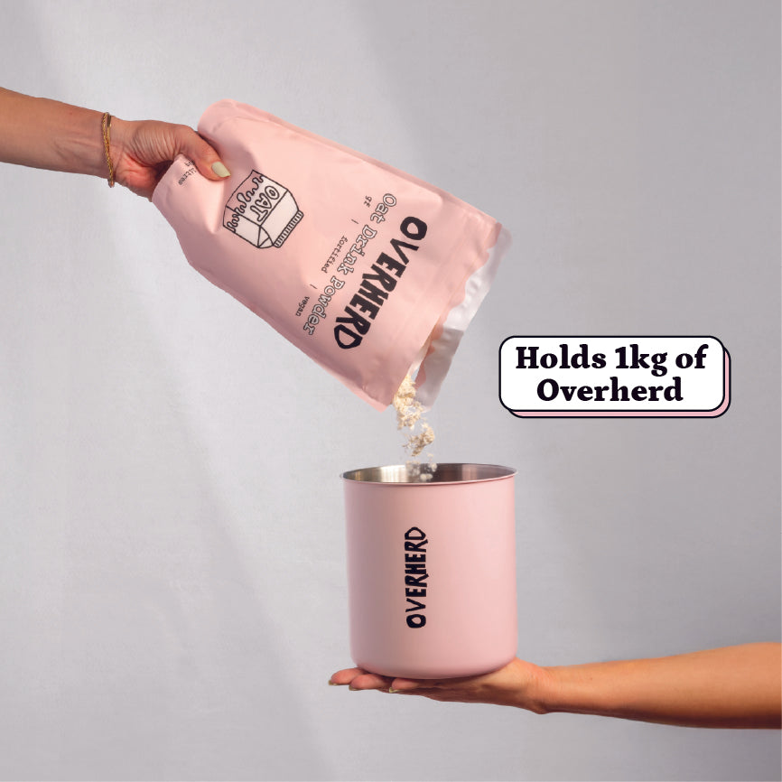 Pouring a pouch of oat milk powder into the Overherd storage tin