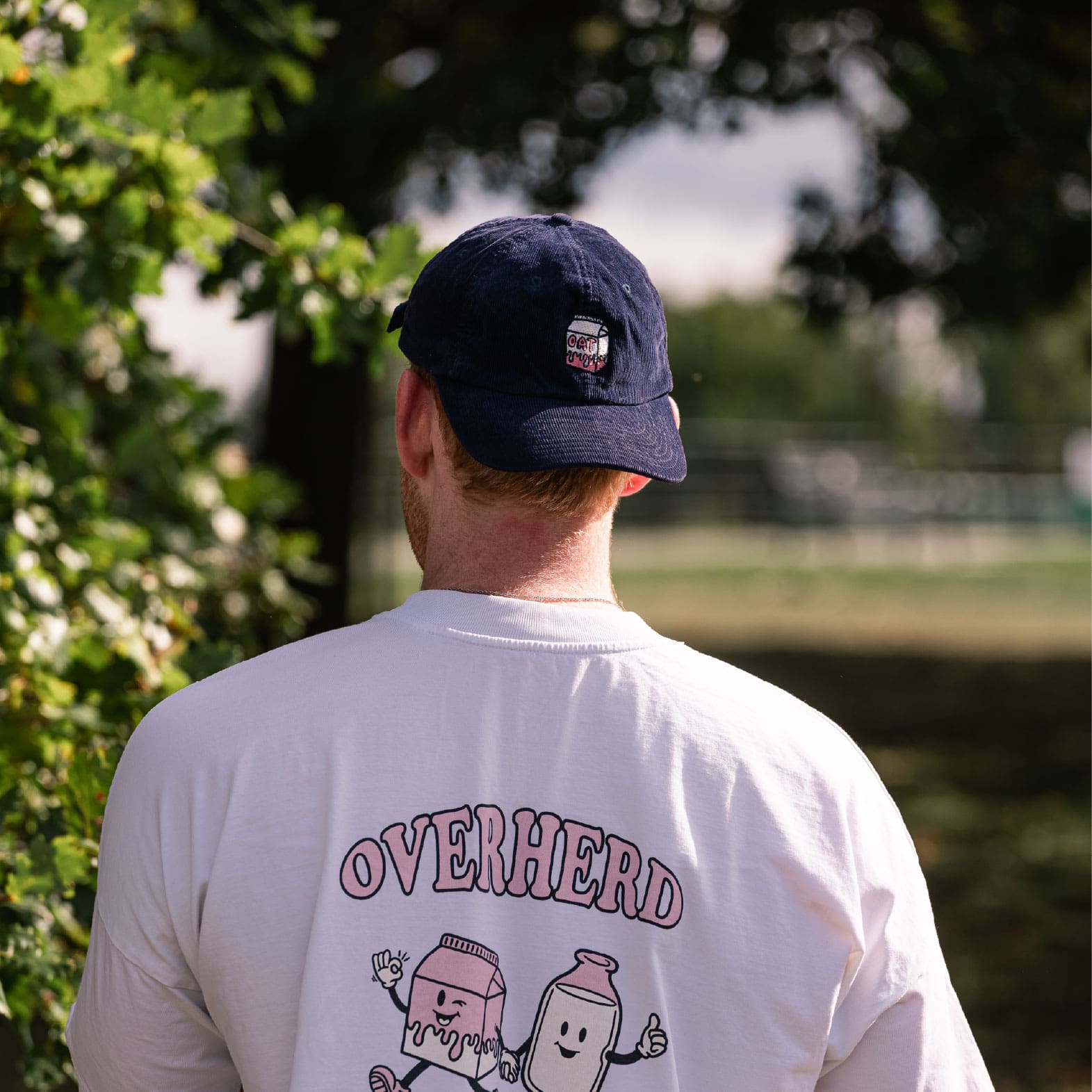 Man wearing backward navy oat milk cap
