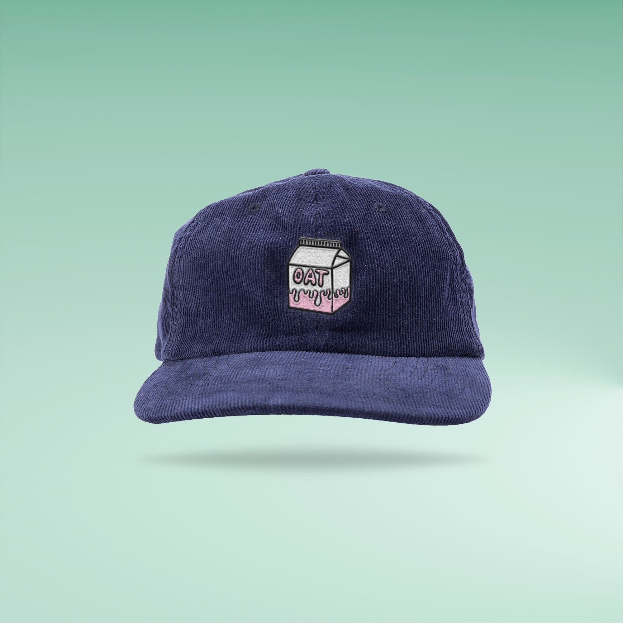 Overherd navy corduroy cap with embroidered oat milk logo on green gradient background