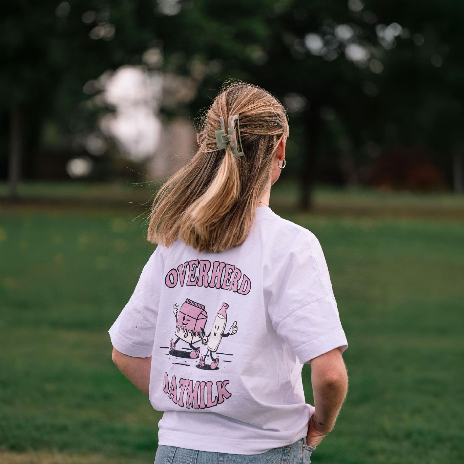 Girl wearing white oat milk t shirt in a park