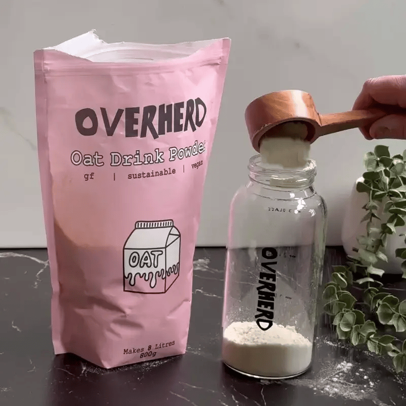 Shaking powdered oat milk in a glass bottle